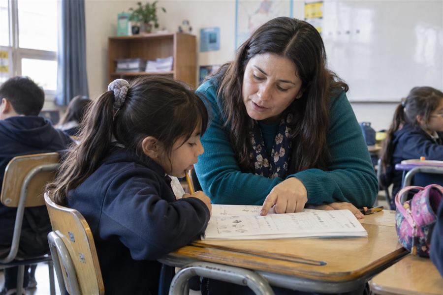 Educadora acompañando a una estudiante en una actividad de aprendizaje