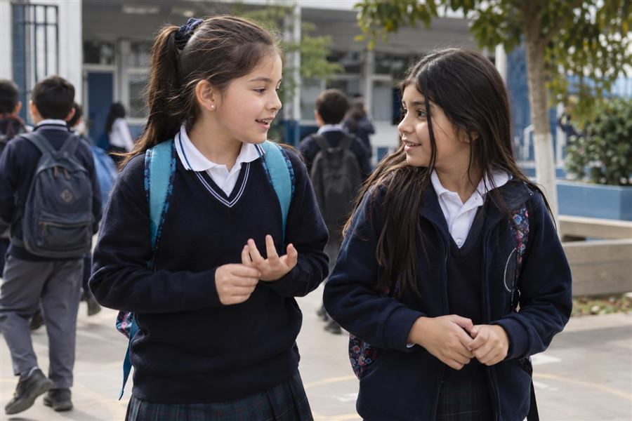 Niñas estudiantes conversando en el patio del colegio
